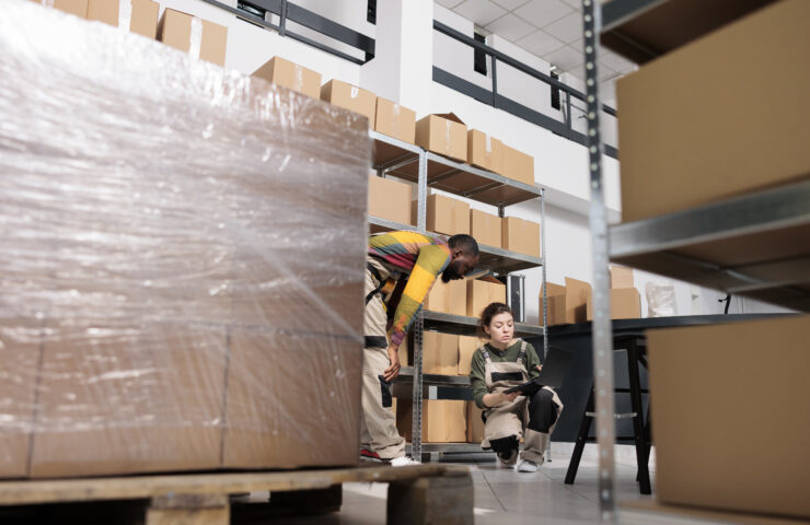 Storehouse employees comparing freight shipping invoice