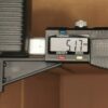 Digital caliper showing 51.1 mm measurement, jaws around a piece of cardboard.